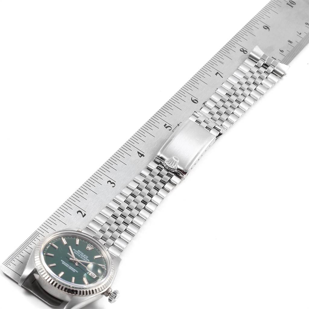The image shows a Rolex Vintage Collection 1601 Men's Stainless Steel Green Dial 1601 Men's Stainless Steel Green Dial watch lying flat with a measuring tape, highlighting the silver bracelet and partially the watch face.