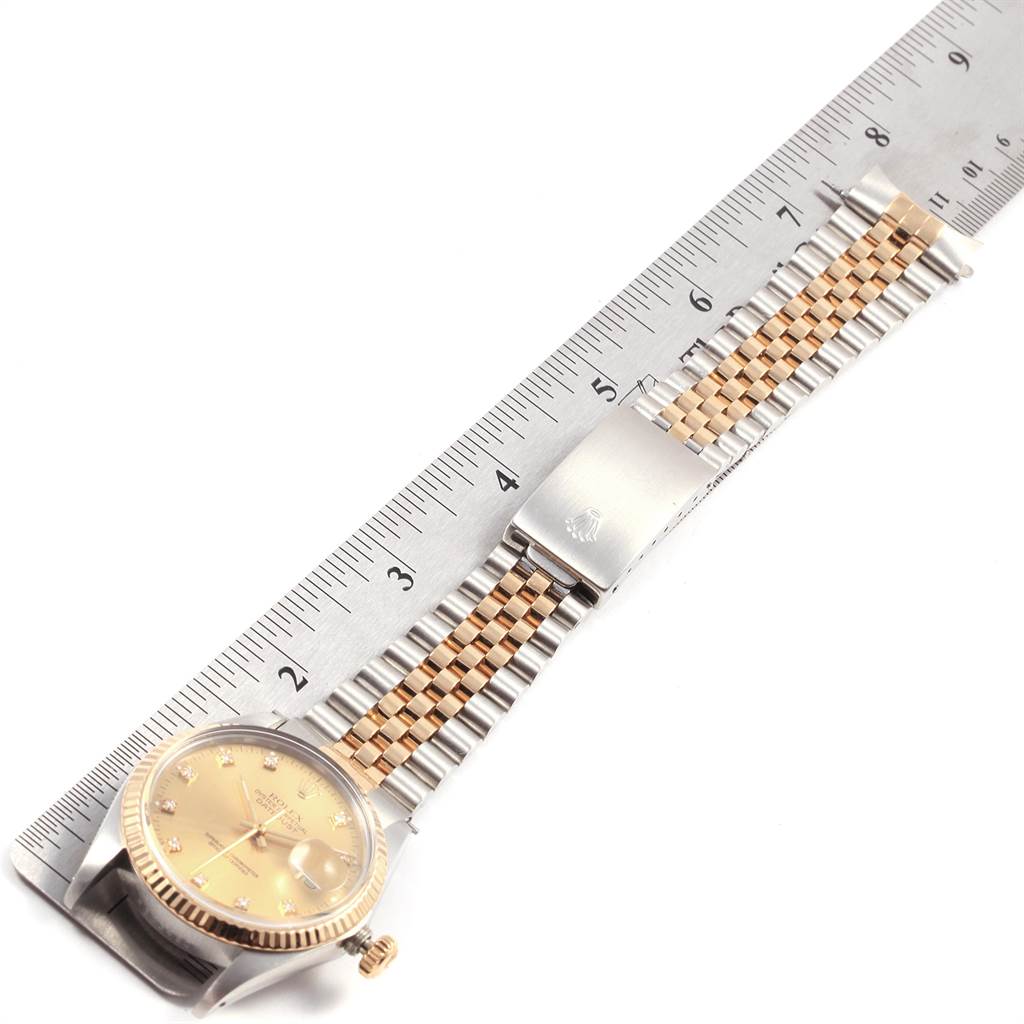 The image shows the Rolex Vintage Collection 16013 Men's Stainless Steel Champagne Dial 16013 Men's Stainless Steel Champagne Dial watch laid flat on a ruler, displaying the face, crown, and bracelet in detail.