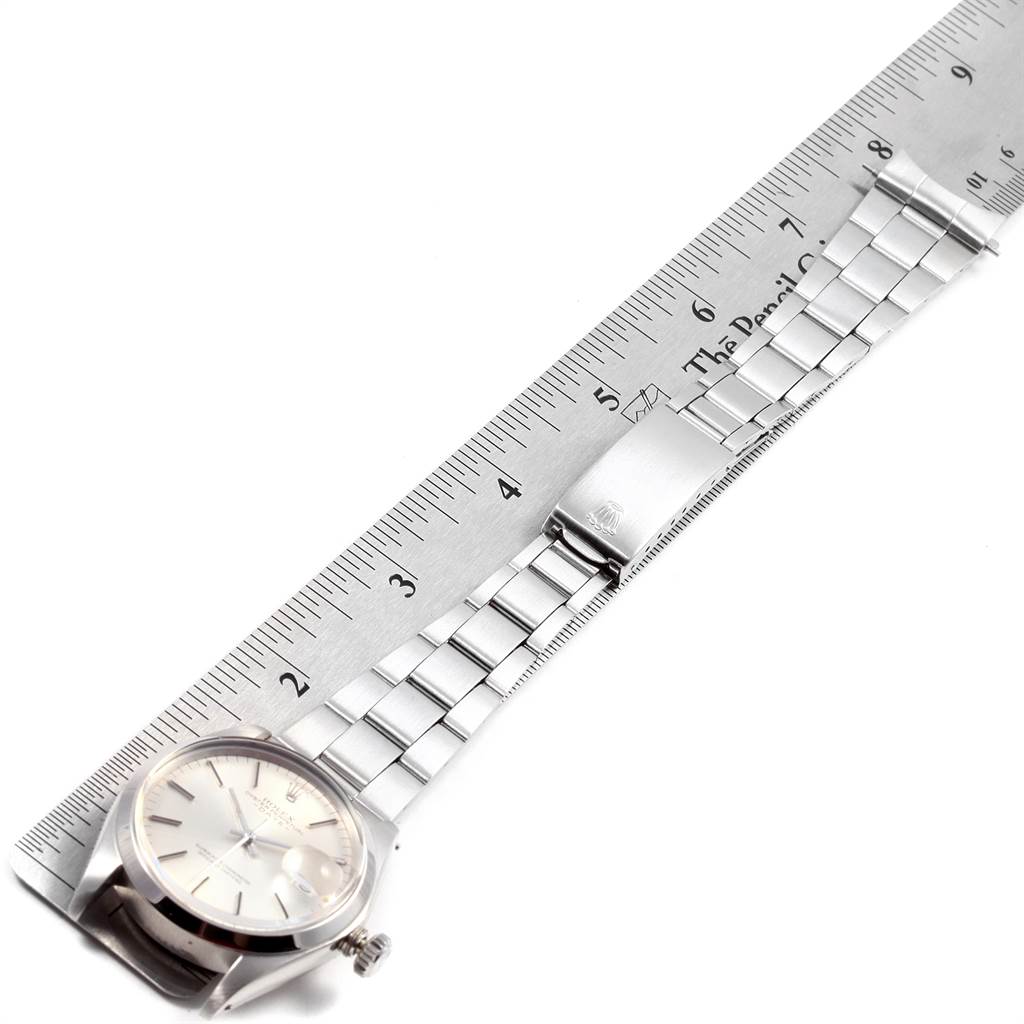 The image shows the Rolex Vintage Collection 1500 Men
s Stainless Steel Silver Dial 1500 Men
s Stainless Steel Silver Dial watch laid flat with a ruler to measure the length of the stainless steel bracelet.