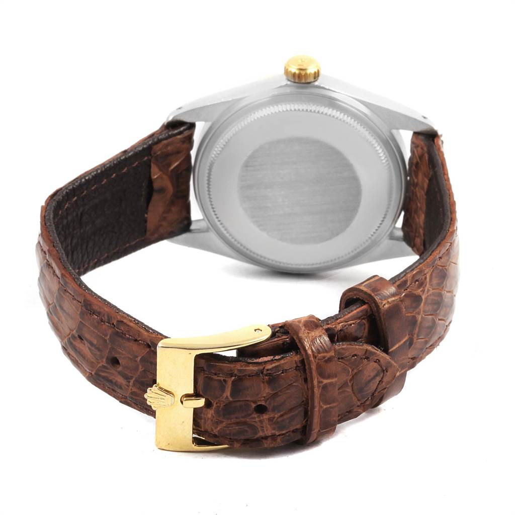 The image shows the back of a Rolex Vintage Collection 16013 Men
s Stainless Steel Black Dial 16013 Men
s Stainless Steel Black Dial watch, highlighting its leather strap and gold buckle.