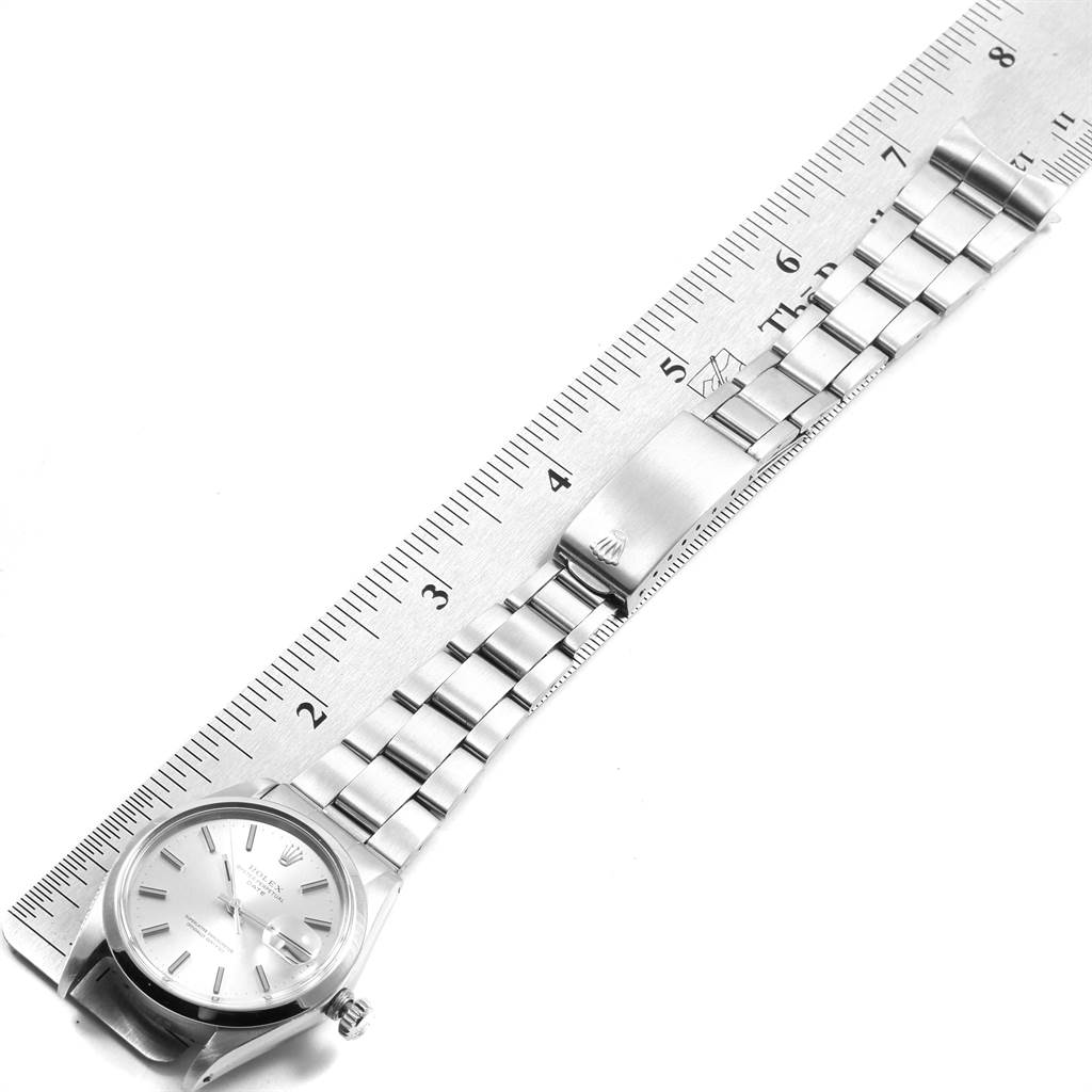 This image shows the face, bezel, and bracelet of a Rolex Vintage Collection 1500 Men's Stainless Steel Silver Dial 1500 Men's Stainless Steel Silver Dial model watch alongside a ruler for scale.
