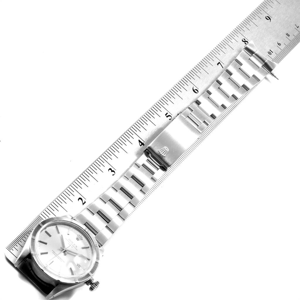 The image shows a top-down view of a Rolex Vintage Collection 1501 Men's Stainless Steel Silver Dial 1501 Men's Stainless Steel Silver Dial watch, specifically its face, bracelet, and clasp alongside a ruler.