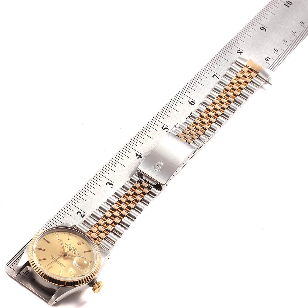 The image shows the Rolex Vintage Collection 16013 Men's Stainless Steel Champagne Dial 16013 Men's Stainless Steel Champagne Dial watch flat with its full bracelet extended alongside a ruler for measurement.