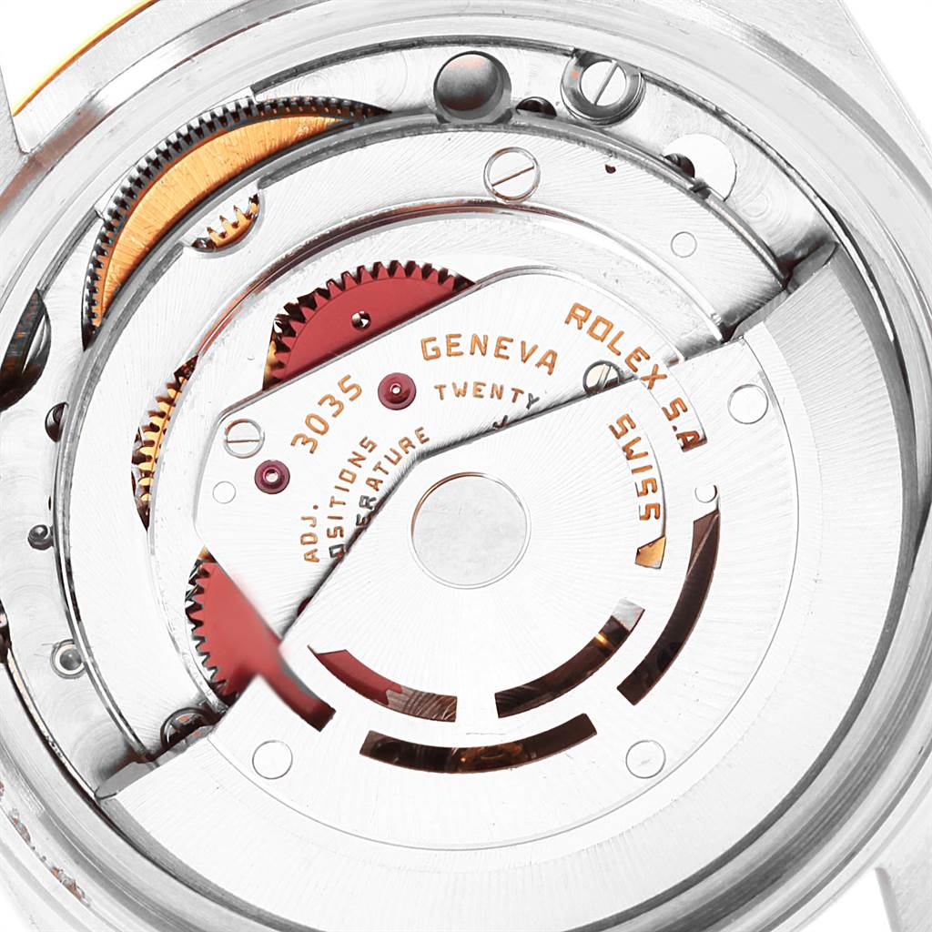 The image shows a close-up of the movement mechanism of a Vintage Collection Rolex watch, displaying gears and components.