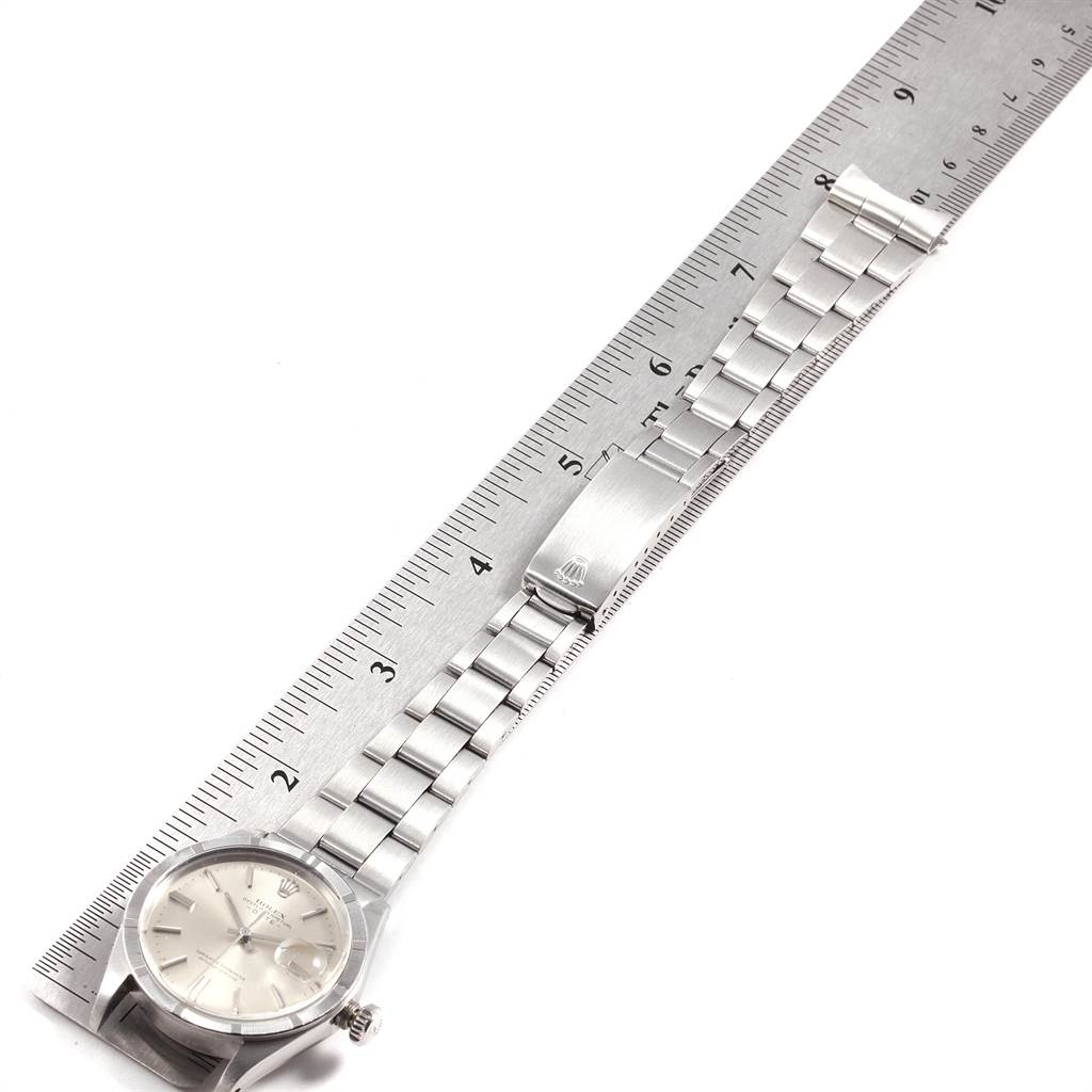 The image shows a Rolex Vintage Collection 1501 Men's Stainless Steel Silver Dial 1501 Men's Stainless Steel Silver Dial watch placed on a ruler, highlighting the face and metal bracelet band with a clasp.