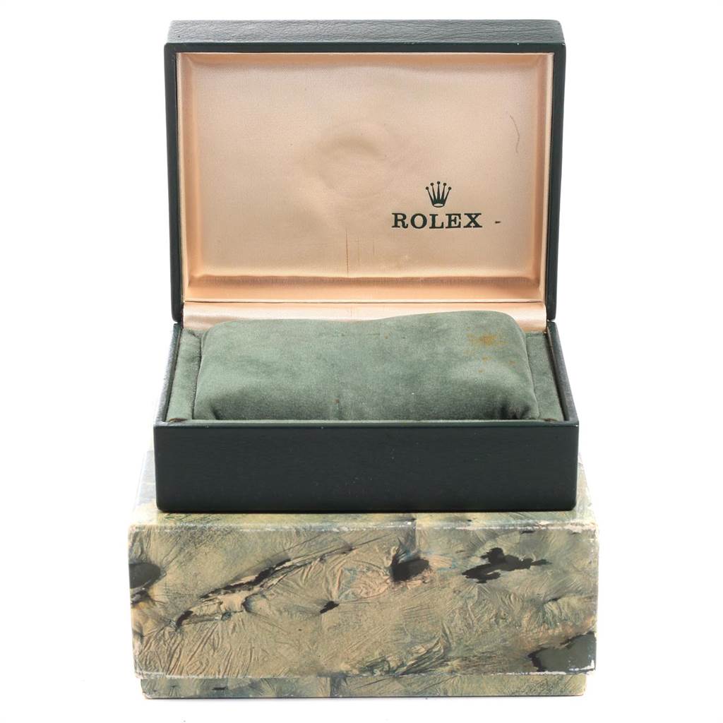 The image shows the open box of a Vintage Collection model Rolex, with the interior cushion and the exterior marble-patterned box.