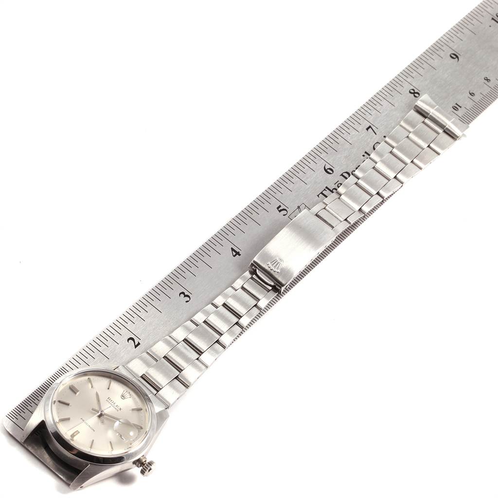 The Vintage Collection Rolex watch is shown horizontally, displaying its dial, bracelet, and clasp next to a ruler.