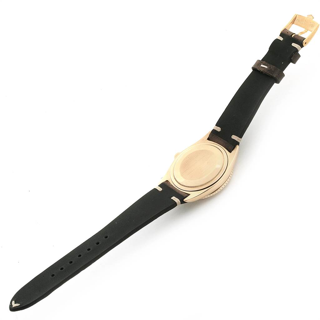 The image shows the back view of a Rolex Vintage Collection 1625 Men
s Yellow Gold Silver Dial 1625 Men
s Yellow Gold Silver Dial watch with a black leather strap.