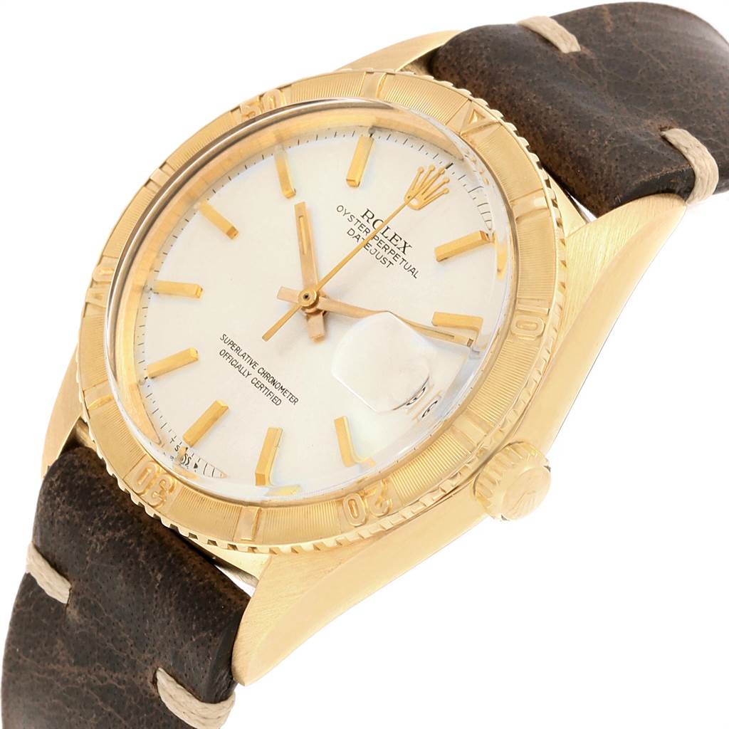 The image shows a Rolex Vintage Collection 1625 Men
s Yellow Gold Silver Dial 1625 Men
s Yellow Gold Silver Dial Oyster Perpetual Datejust watch at an angle highlighting its face, bezel, and leather strap.