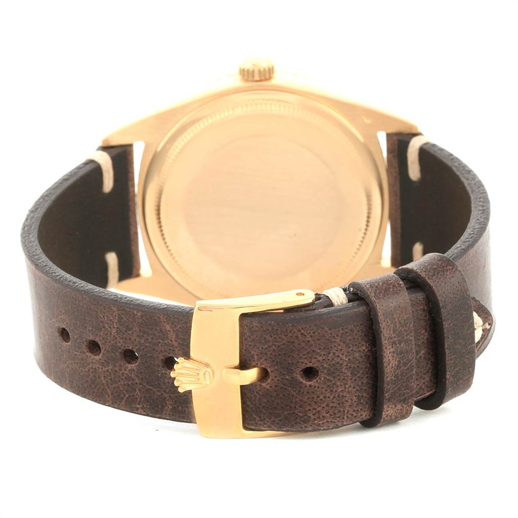 The image shows the back of a Rolex Vintage Collection 1625 Men
s Yellow Gold Silver Dial 1625 Men
s Yellow Gold Silver Dial model watch with a brown leather strap and gold buckle.