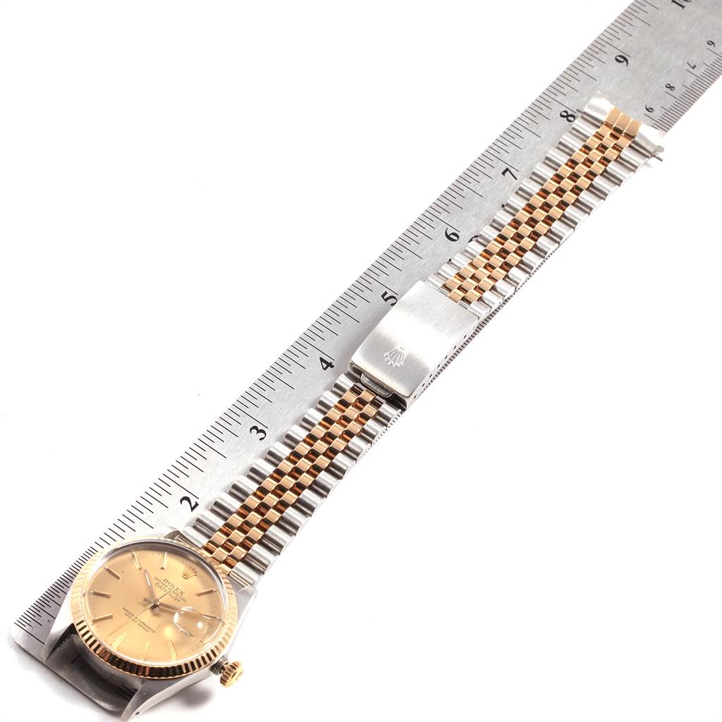 The Rolex Vintage Collection 16013 Men's Stainless Steel Champagne Dial 16013 Men's Stainless Steel Champagne Dial watch is shown from a top view, displaying its face, bezel, dual-tone band, and clasp, alongside a ruler for scale.