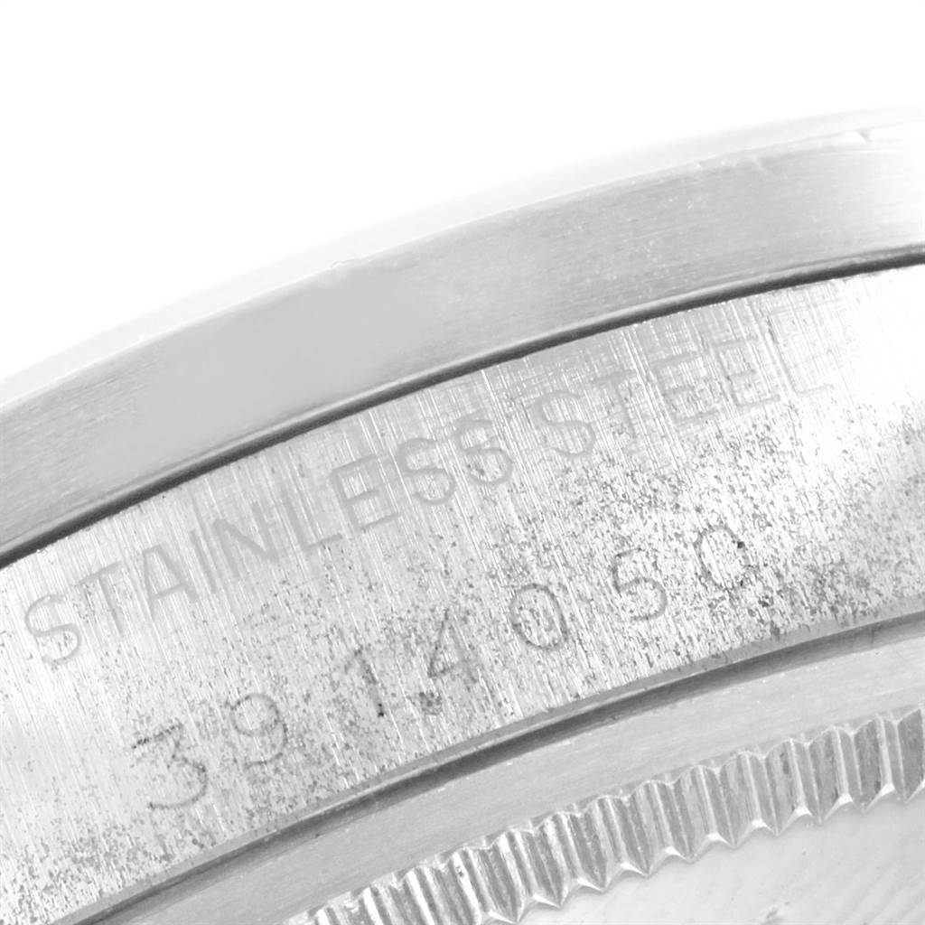 The image shows a close-up of the side of a stainless steel casing of the Rolex Vintage Collection 1501 Men's Stainless Steel Black Dial 1501 Men's Stainless Steel Black Dial model, highlighting part of the engraved text and watch bezel.
