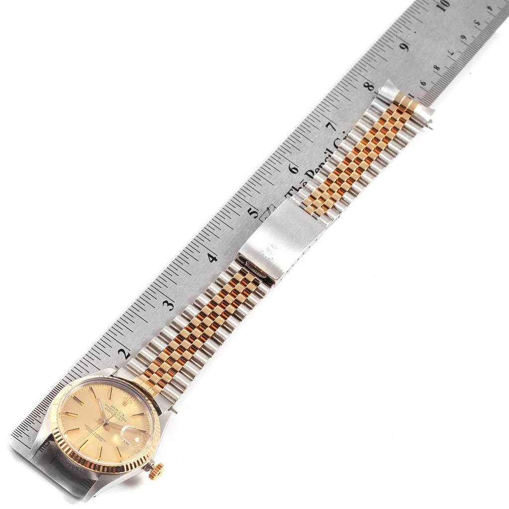 The image shows a Rolex Vintage Collection 16013 Men's Stainless Steel Champagne Dial 16013 Men's Stainless Steel Champagne Dial watch from the top view, highlighting its face, bracelet, and crown, against a ruler for scale.