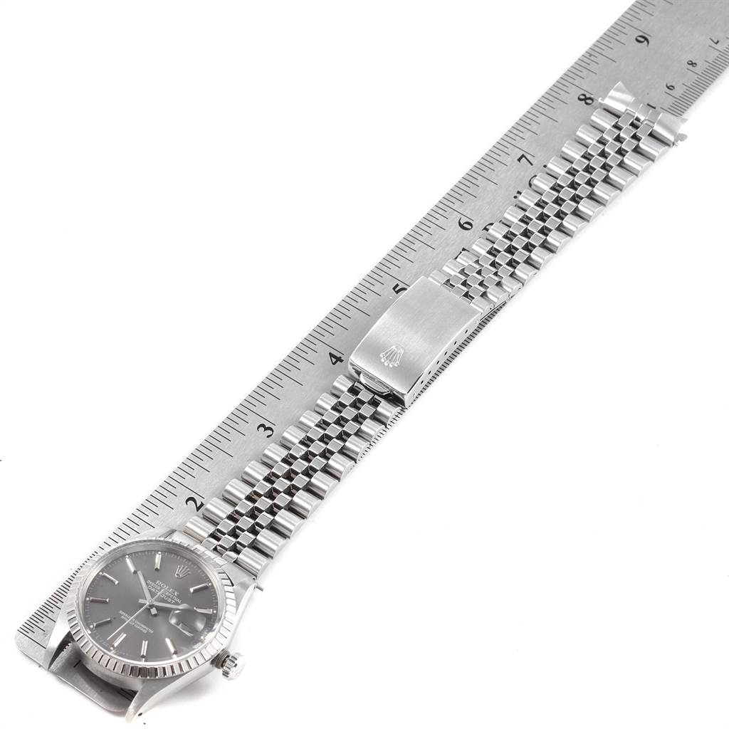 The Rolex Vintage Collection 16030 Men's Stainless Steel Grey Dial 16030 Men's Stainless Steel Grey Dial watch is shown in a top-down view showcasing its silver bracelet, clasp, and face, alongside a ruler.