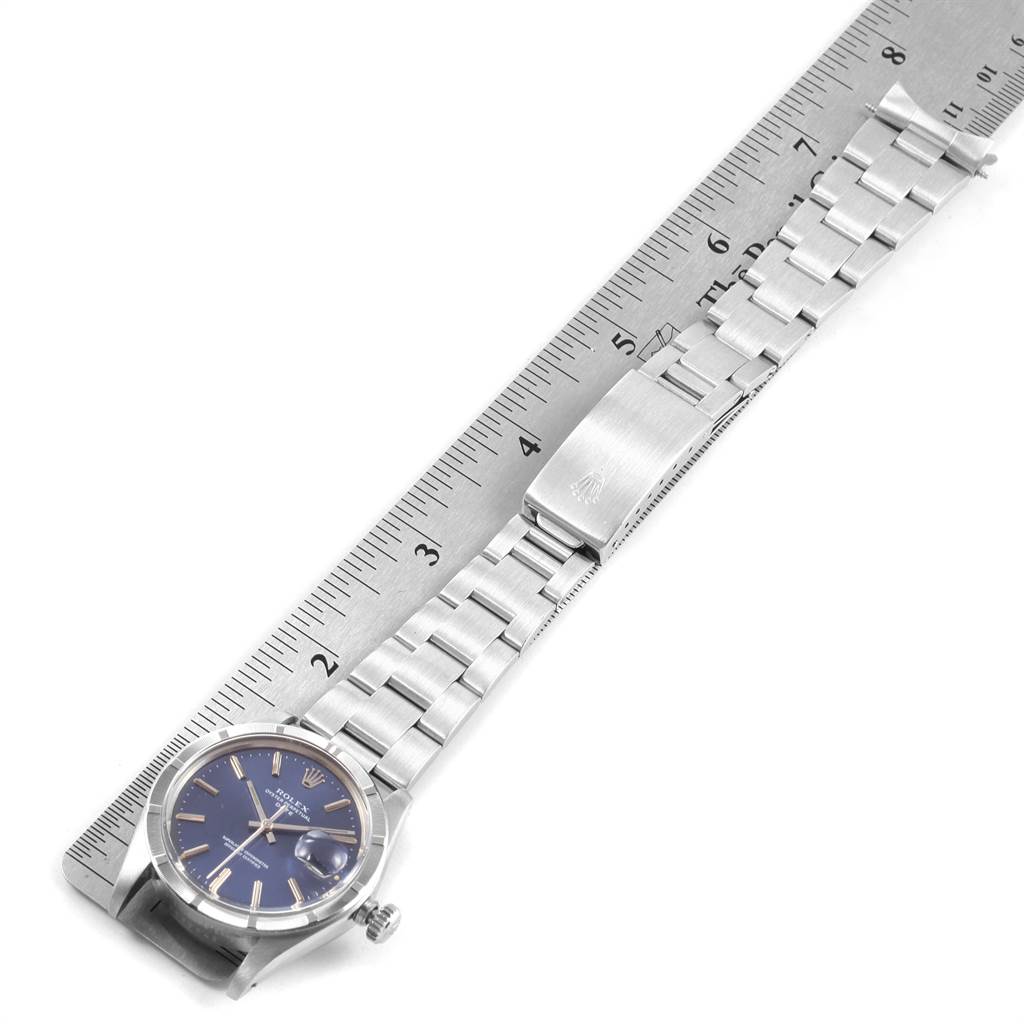 The image shows a flat-lay of a Rolex Vintage Collection 1501 Men's Stainless Steel Blue Dial 1501 Men's Stainless Steel Blue Dial watch with its metal band alongside a ruler for scale.