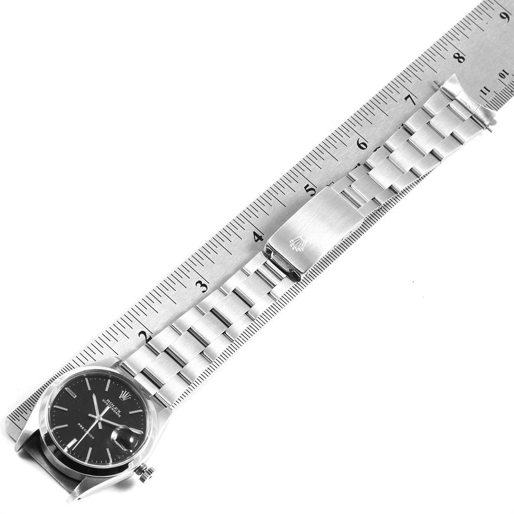 The image shows a Rolex Vintage Collection 6694 Men's Stainless Steel Black Dial 6694 Men's Stainless Steel Black Dial watch laid next to a ruler, displaying the watch face, strap, and clasp.