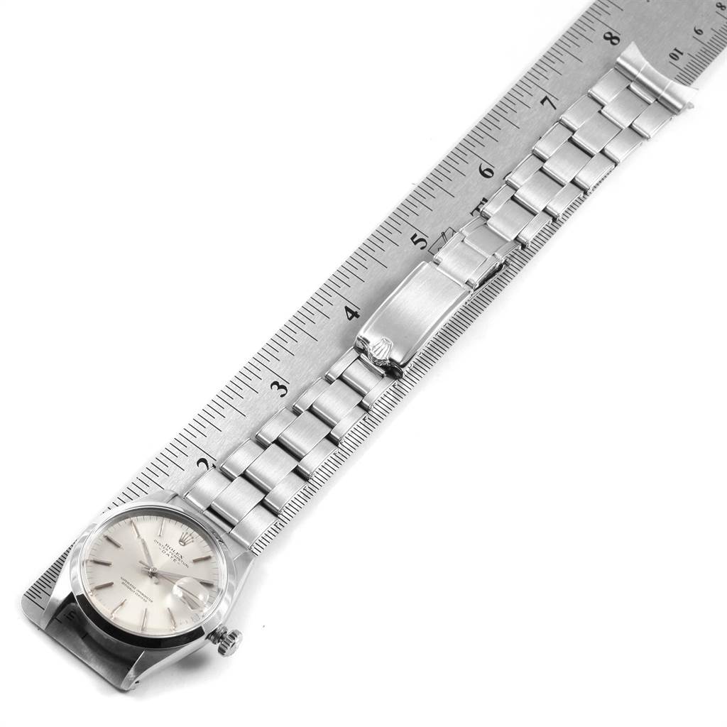 The image features a Rolex Vintage Collection 1500 Men's Stainless Steel Silver Dial 1500 Men's Stainless Steel Silver Dial watch, showcasing the face, band, clasp, and part of a ruler for measurement.