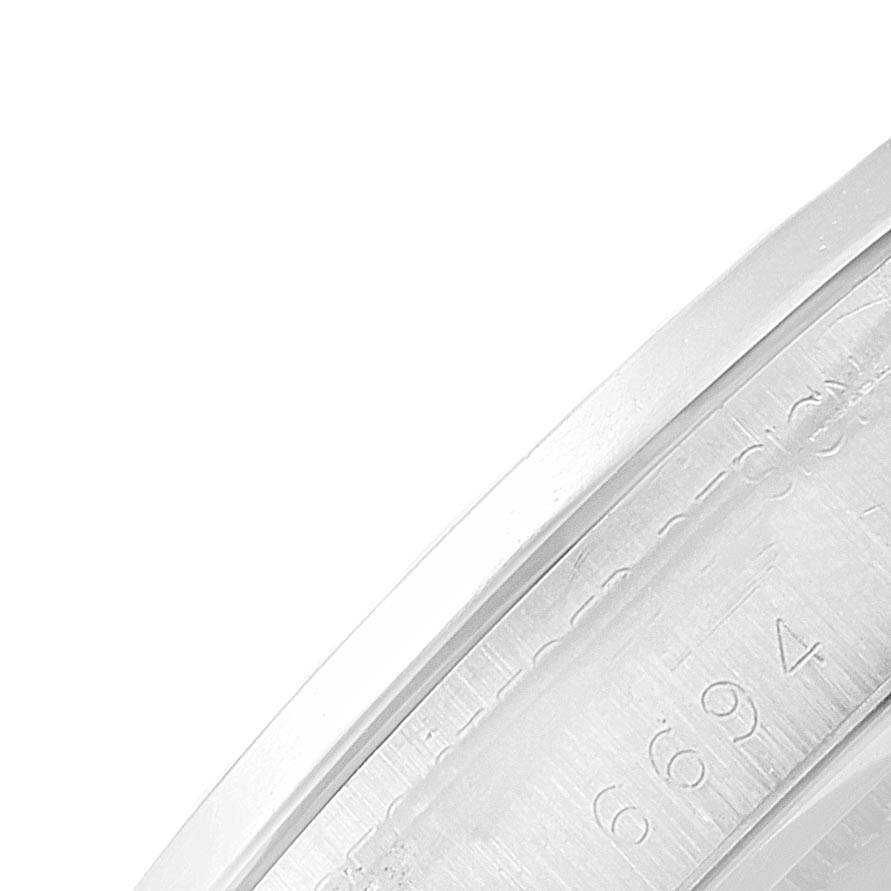 This image shows a close-up of the bezel and etched serial number of the Rolex Vintage Collection 6694 Men's Stainless Steel Silver Dial 6694 Men's Stainless Steel Silver Dial watch.