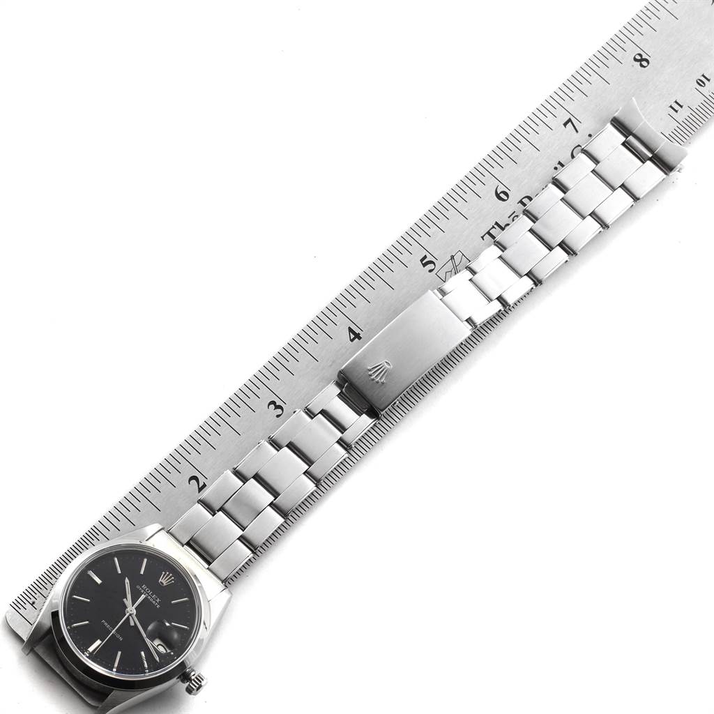 The image shows the face, bracelet, and clasp of a Rolex Vintage Collection 6694 Men's Stainless Steel Black Dial 6694 Men's Stainless Steel Black Dial watch alongside a ruler.