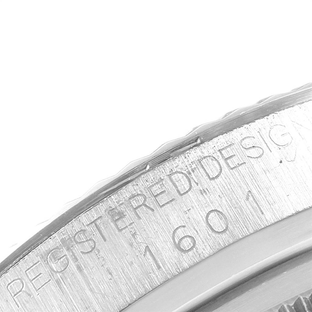 This is a close-up view of the side of the bezel on a Rolex Vintage Collection 1601 Men's Stainless Steel Silver Dial 1601 Men's Stainless Steel Silver Dial model watch, showing part of the engraved text.