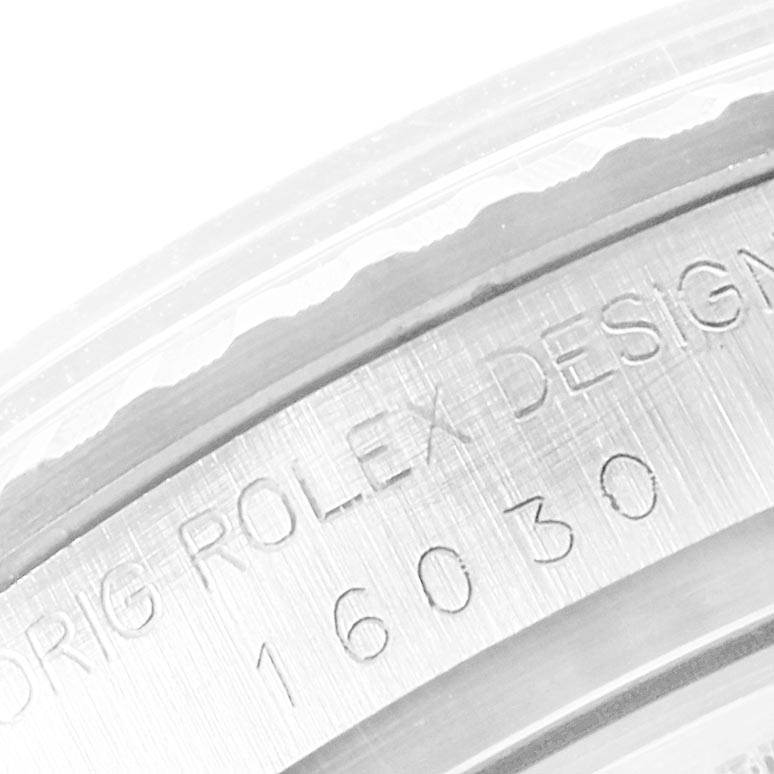 The image shows a close-up of the side of a Rolex Vintage Collection 16030 Men's Stainless Steel Silver Dial 16030 Men's Stainless Steel Silver Dial model, displaying its engraved serial number.
