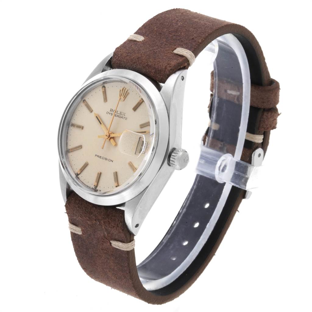The image shows a side angle of a Vintage Collection Rolex watch featuring a brown leather strap and a cream dial.