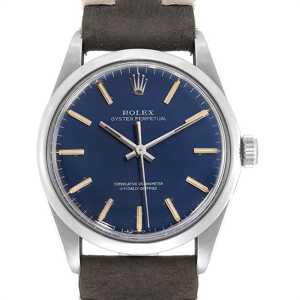 The image shows a front view of the Rolex Vintage Collection 1002 Men's Stainless Steel Blue Dial 1002 Men's Stainless Steel Blue Dial Oyster Perpetual watch, highlighting its blue dial, gold indices, and leather strap.
