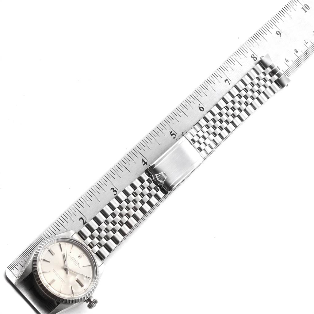 The Rolex Vintage Collection 1603 Men's Stainless Steel Silver Dial 1603 Men's Stainless Steel Silver Dial model watch is shown from a top-down angle, displaying the dial, bezel, and metal bracelet alongside a ruler for scale.