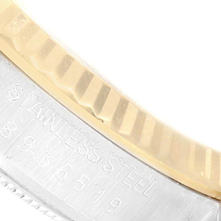 The image shows a close-up angle of the stainless steel and gold fluted bezel of a Vintage Collection Rolex watch.