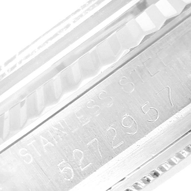 The image shows a close-up of the engraved side of a Rolex Vintage Collection 1601 Men's Stainless Steel Black Dial 1601 Men's Stainless Steel Black Dial watch, featuring "Stainless Steel" and a serial number.