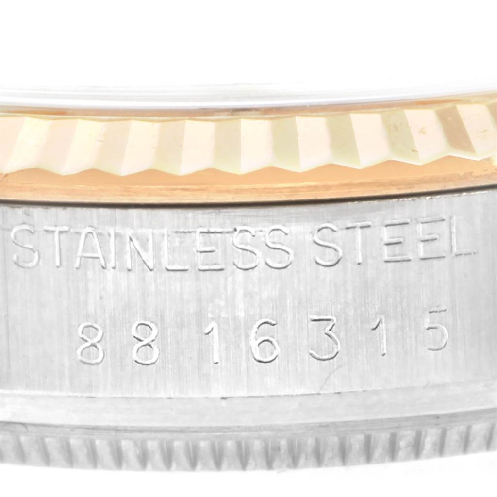 Close-up of the side of the Rolex Vintage Collection 16013 Men's Stainless Steel Champagne Dial 16013 Men's Stainless Steel Champagne Dial watch showing its stainless steel marking and a portion of the bezel.