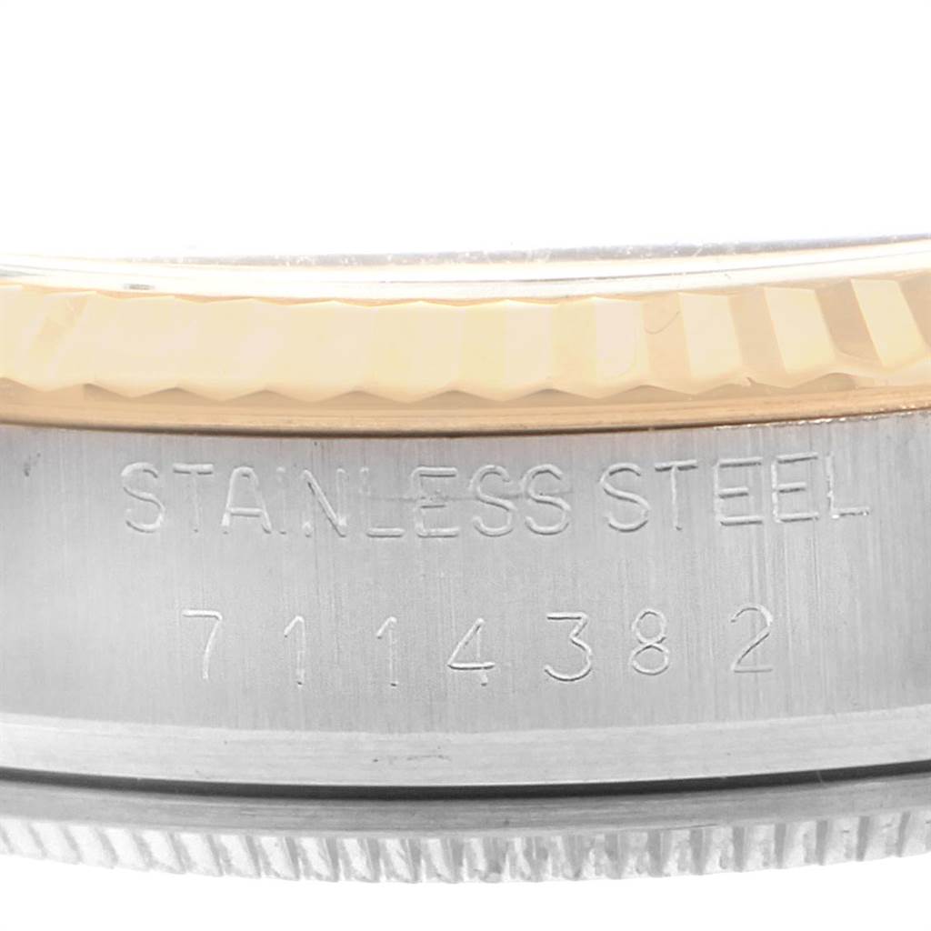 This image shows a close-up of the stainless steel casing and bezel with serial number engraving on a Vintage Collection Rolex watch.