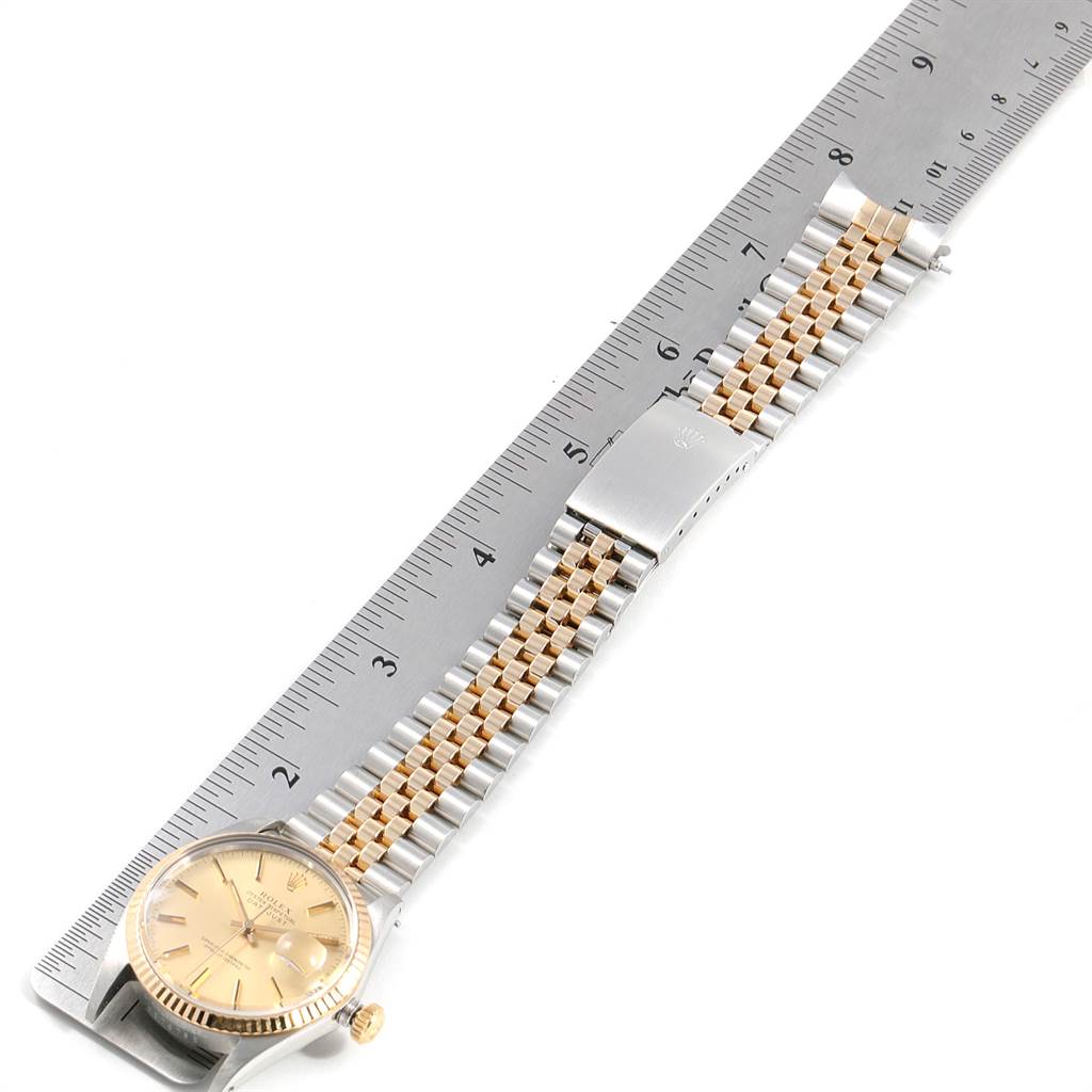 The image shows the Rolex Vintage Collection 16013 Men's Steel and Gold (two tone) Champagne Dial 16013 Men's Steel and Gold (two tone) Champagne Dial watch laid flat next to a ruler, displaying its dial, bezel, and two-tone bracelet.