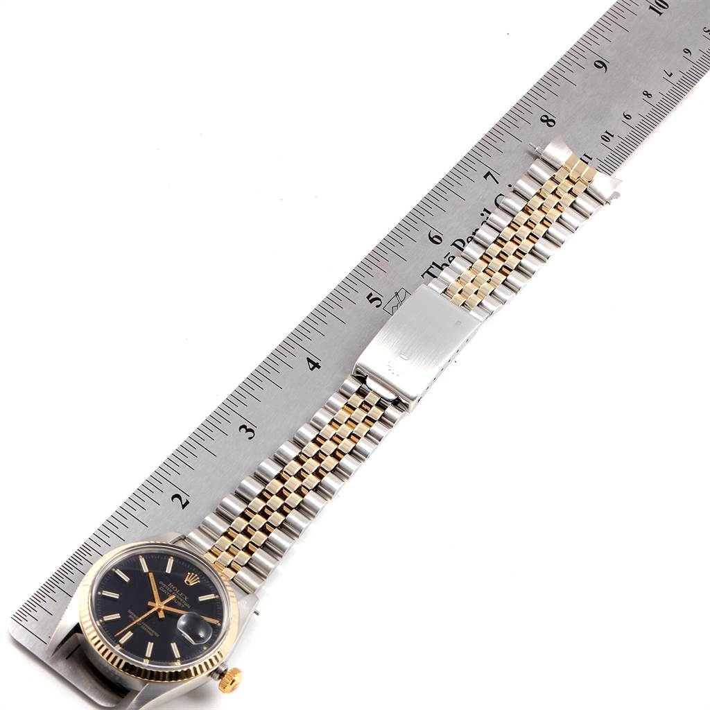 The image shows a top-down view of a Rolex Vintage Collection 16013 Men's Stainless Steel Black Dial 16013 Men's Stainless Steel Black Dial watch with a two-tone bracelet and a ruler for scale.