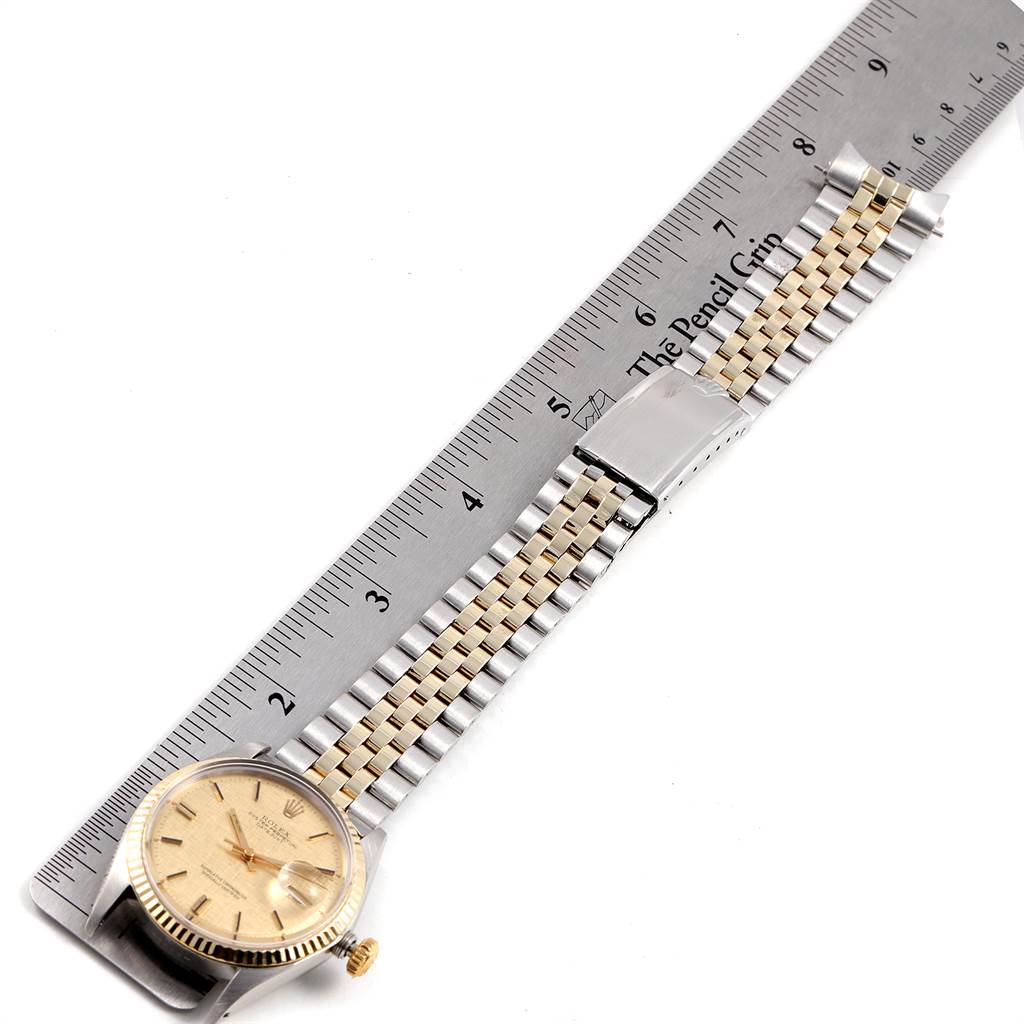 The Rolex Vintage Collection 1601 Men
s Steel and Gold (two tone) Champagne Dial 1601 Men
s Steel and Gold (two tone) Champagne Dial watch is displayed flat with its dial, case, and bracelet shown alongside a ruler for scale.