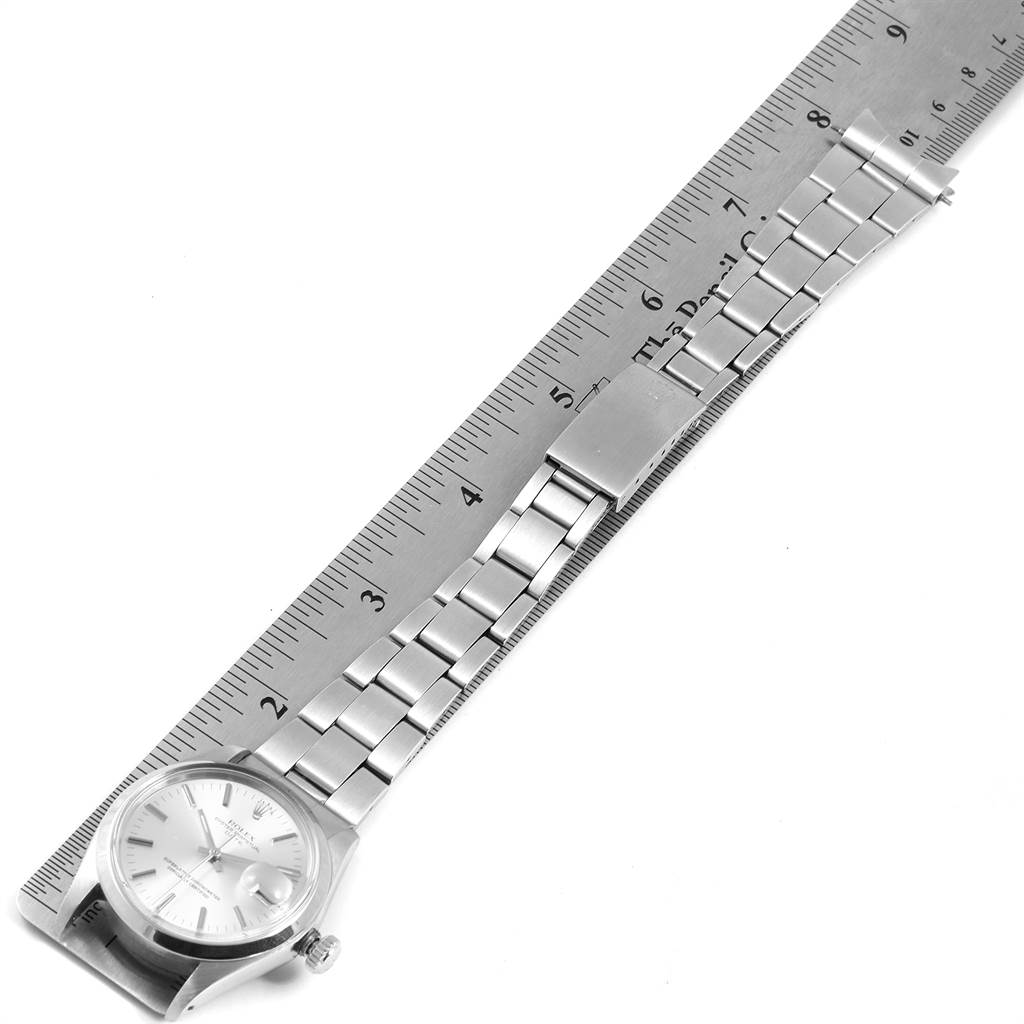 The Rolex Vintage Collection 1500 Men's Stainless Steel Silver Dial 1500 Men's Stainless Steel Silver Dial watch is shown from a top-down angle, displaying the dial, bracelet, and clasp alongside a ruler.