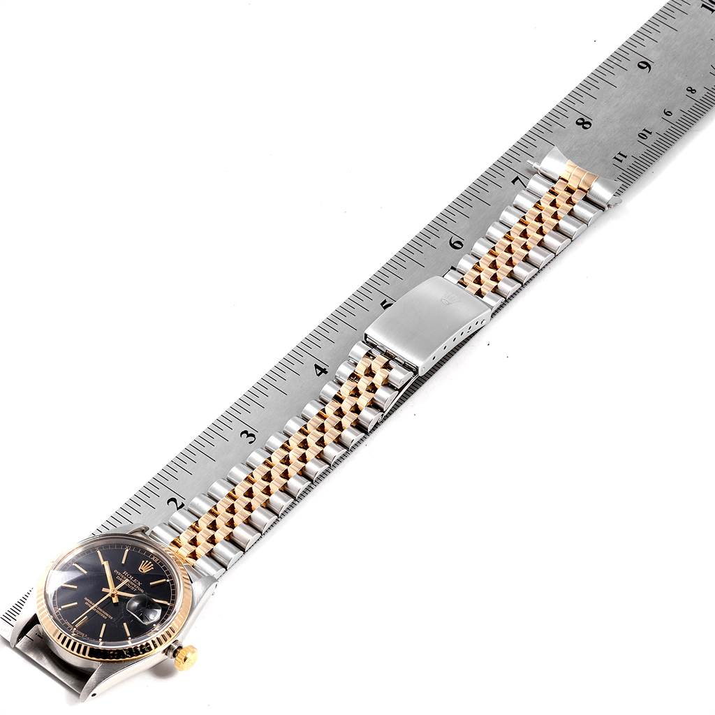The Vintage Collection Rolex watch is shown from a top-down angle, displaying the face, bezel, and band alongside a ruler for scale.