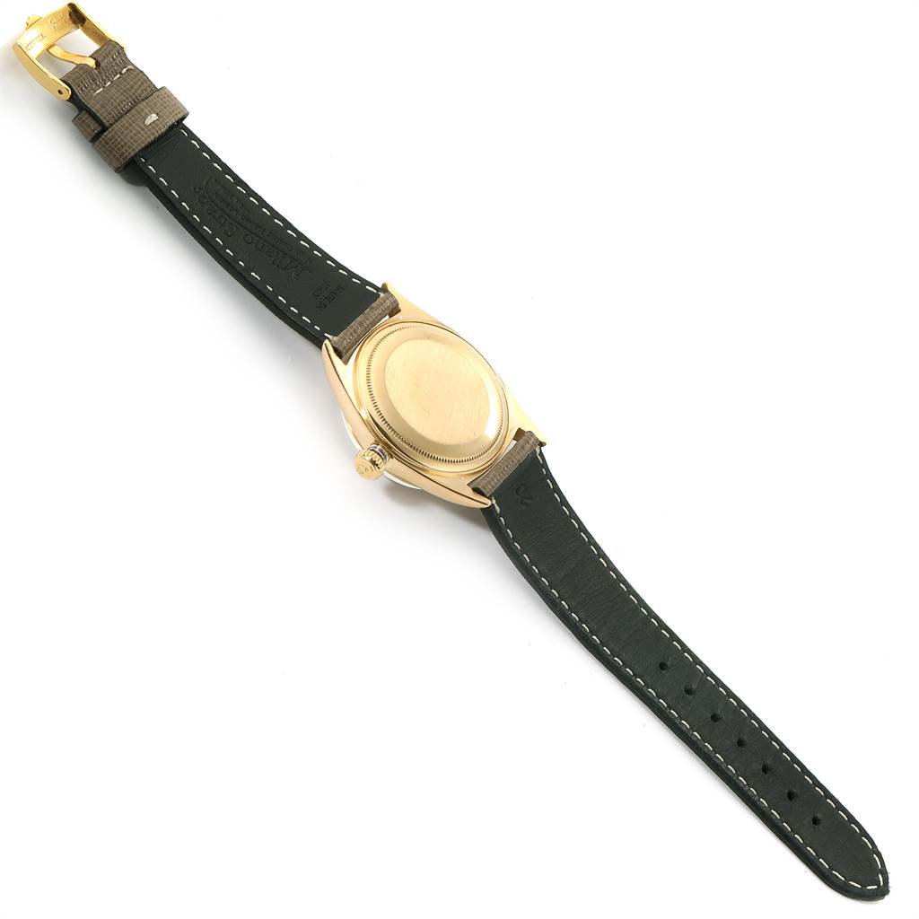 The image shows the back view of a Vintage Collection model Rolex watch, featuring its case back, crown, and leather strap.