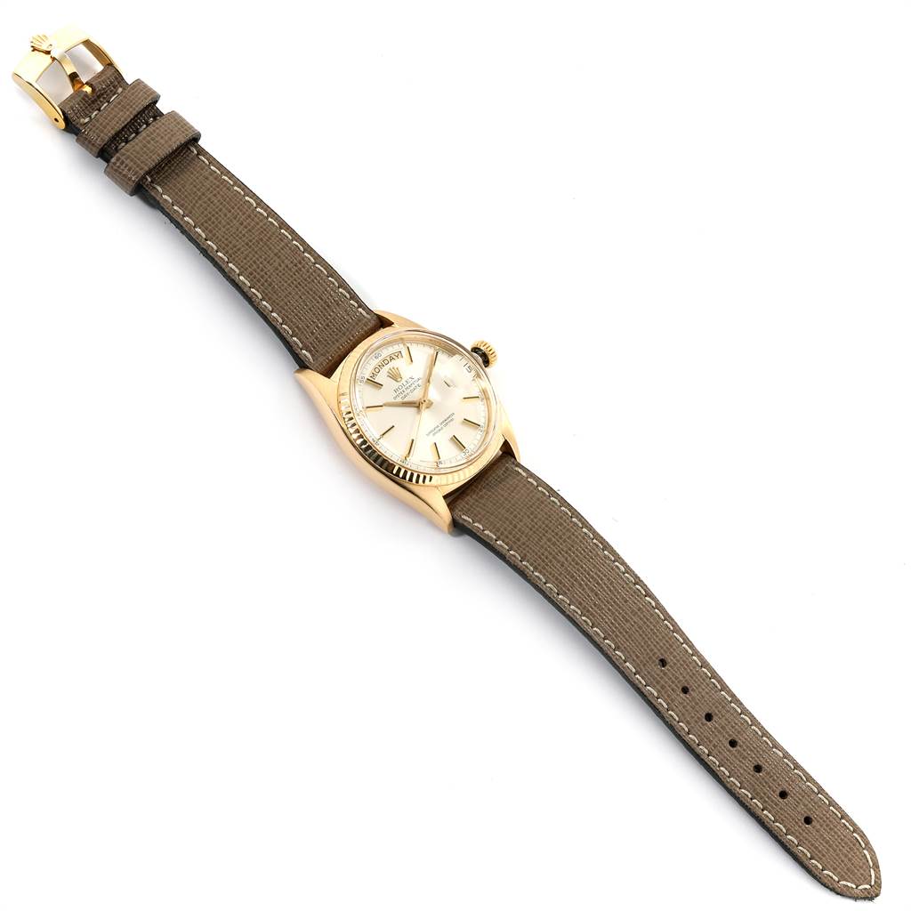 The photo shows a Rolex Vintage Collection 1803 Men's Yellow Gold Silver Dial 1803 Men's Yellow Gold Silver Dial watch from a top-down angle, displaying its dial, case, and entire strap.