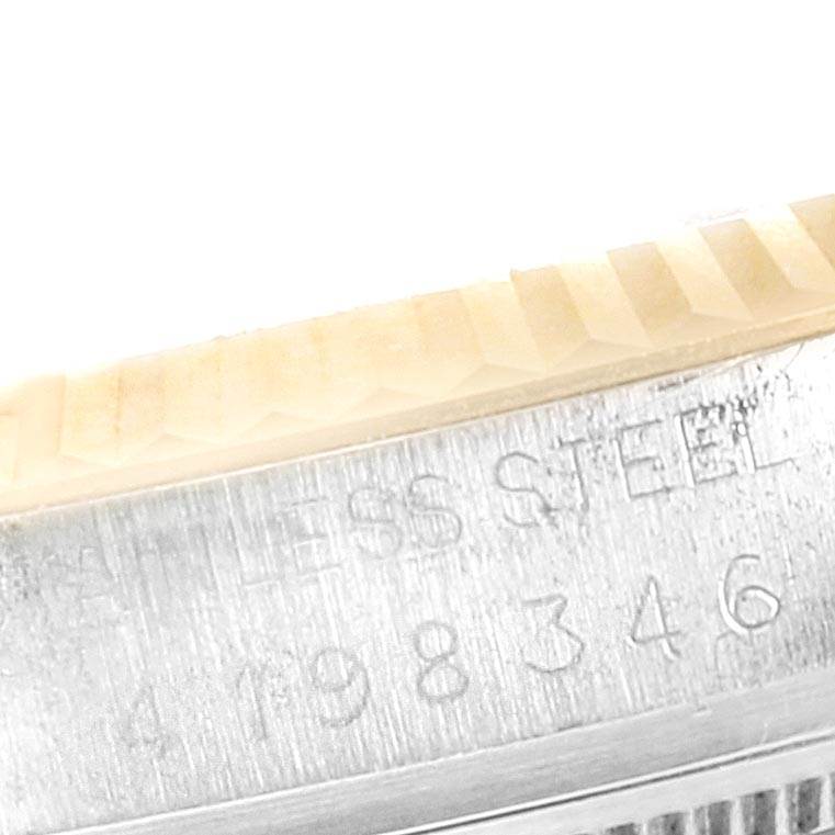 This close-up image shows the engraved bezel and case of the Vintage Collection Rolex watch, highlighting the serial number and "STAINLESS STEEL" inscription.