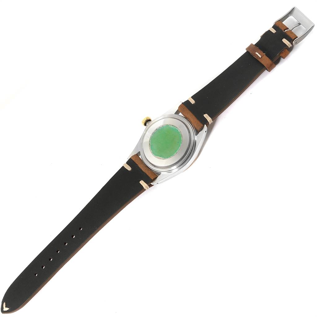 The Vintage Collection Rolex watch is shown from the back, displaying the case back, crown, and leather strap.