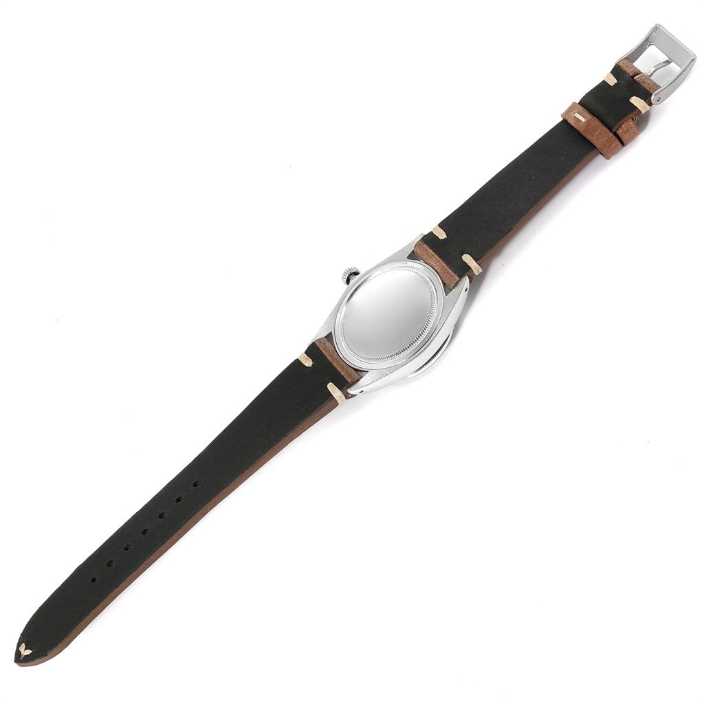 The image shows the Vintage Collection Rolex watch from an overhead angle, highlighting its leather strap and case back.
