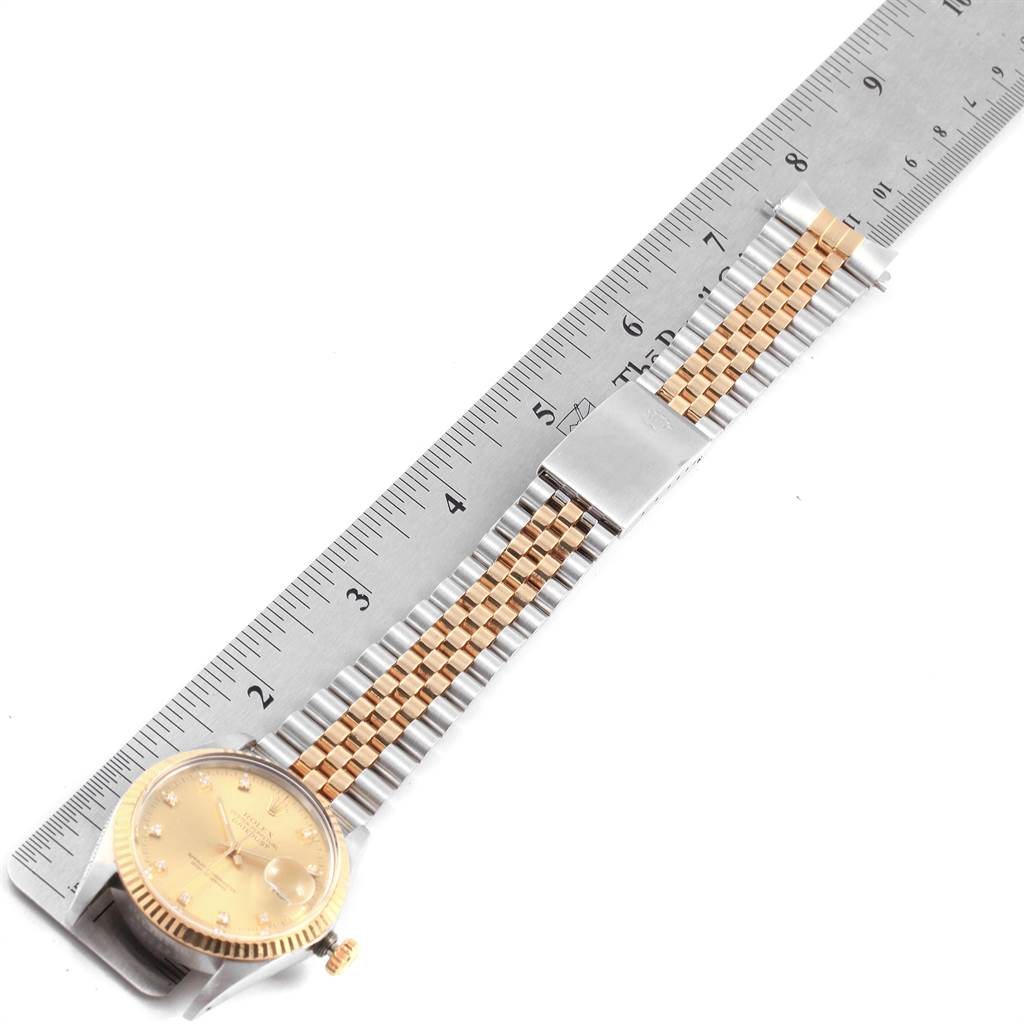 The image shows a Rolex Vintage Collection 16013 Men's Stainless Steel Champagne Dial 16013 Men's Stainless Steel Champagne Dial watch lying flat with a metal ruler placed alongside it.