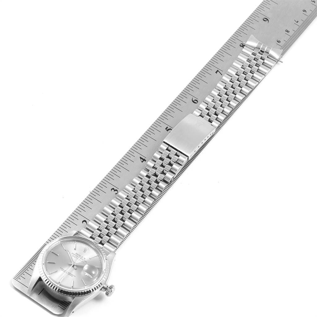 The Rolex Vintage Collection 16014 Men's Stainless Steel Silver Dial 16014 Men's Stainless Steel Silver Dial watch is shown from above, highlighting the face, bracelet, and clasp against a ruler.