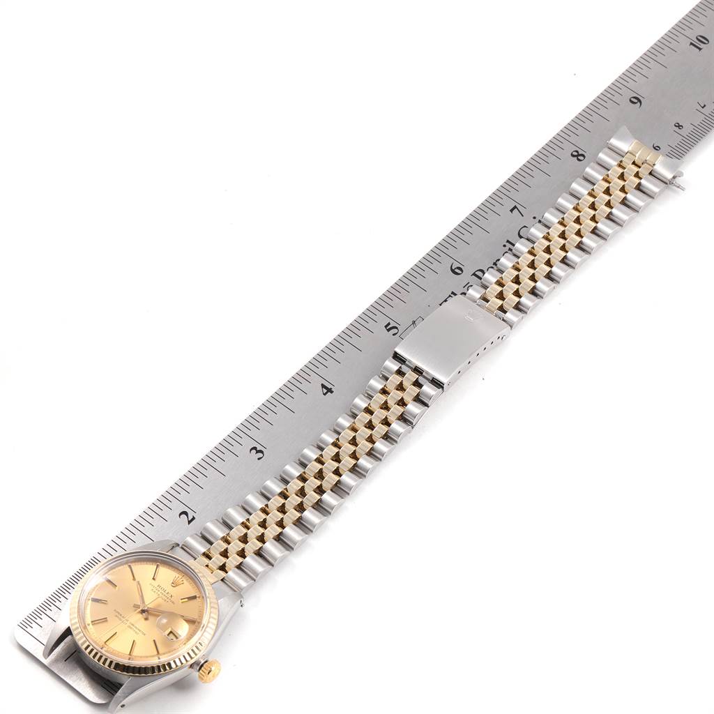 The Rolex Vintage Collection 1601 Men
s Steel and Gold (two tone) Champagne Dial 1601 Men
s Steel and Gold (two tone) Champagne Dial watch is shown from an aerial view with its bracelet and clasp fully extended next to a ruler.