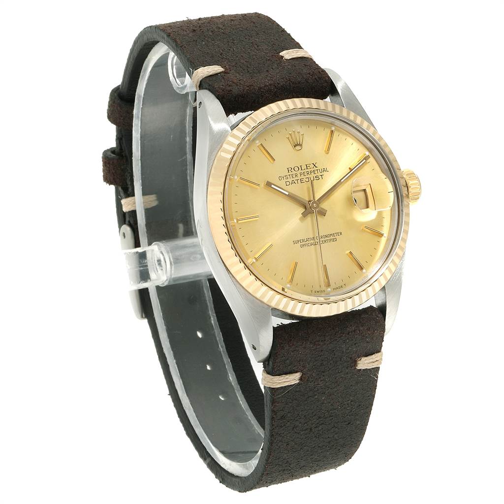 The image shows a Rolex Vintage Collection 16013 Men's Stainless Steel Champagne Dial 16013 Men's Stainless Steel Champagne Dial Datejust watch at an angled view, highlighting its gold dial, fluted bezel, and dark leather strap.