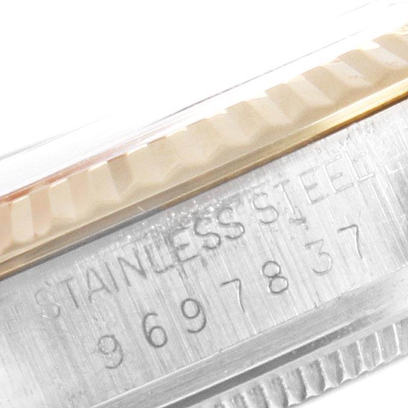 This image shows a close-up of a serial number and part of a stainless steel bezel on a Vintage Collection model Rolex watch.
