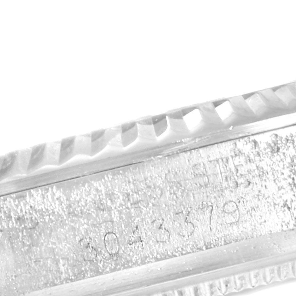 This close-up image shows the serial number and fluted bezel of a Rolex Vintage Collection 1601 Men's Stainless Steel Grey Dial 1601 Men's Stainless Steel Grey Dial model watch.