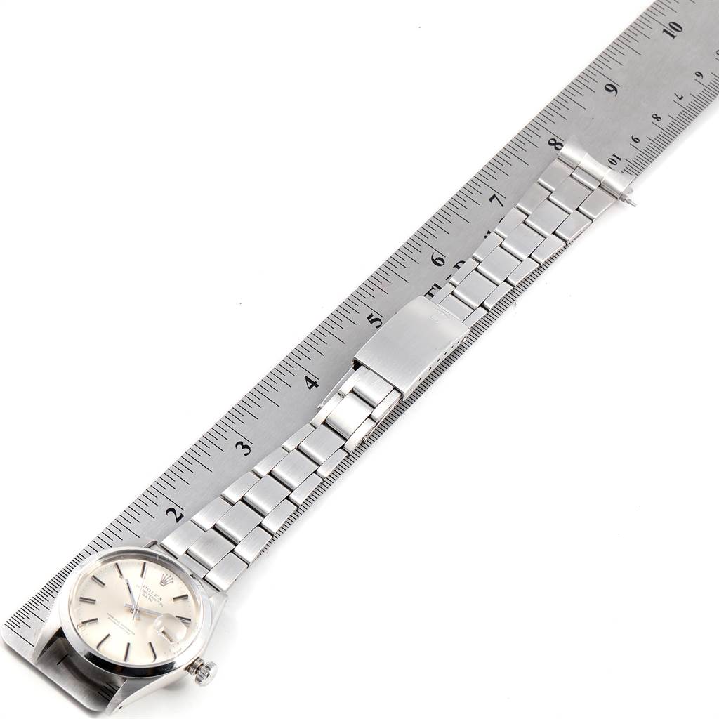The Vintage Collection Rolex watch is shown from a top-down angle, displaying the dial, bracelet, and clasp against a ruler for scale.