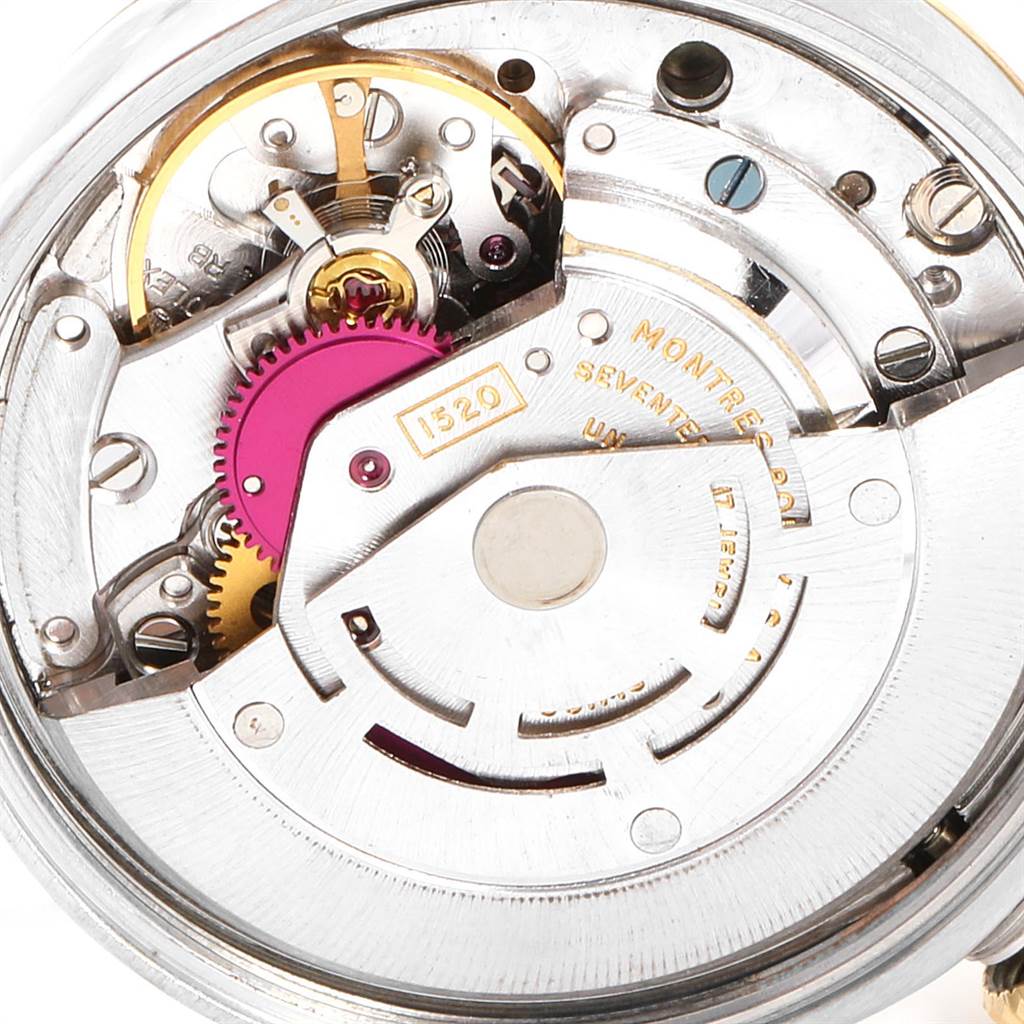 This image shows the intricate inner workings of a Vintage Collection Rolex watch, including gears and other mechanical components, from a top-down angle.